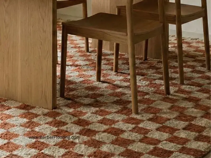 A hand-woven checkered rug in soft terracotta rust and beige tones